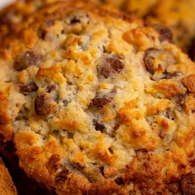 Close-up of a craggy golden chocolate chip cookie, chunks of chocolate showing through the crust.