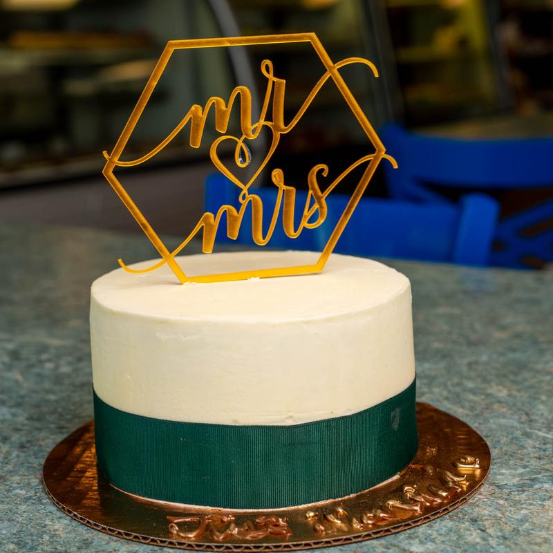 Navy blue and white wedding cake with decoration on top.