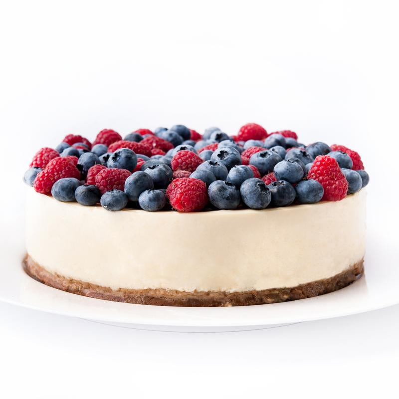 White cake topped with blueberries and raspberries.